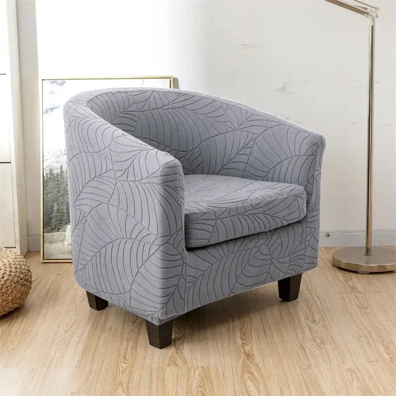 Leaves jacquard tub chair slipcover by Simples Market in light gray with leaf pattern.