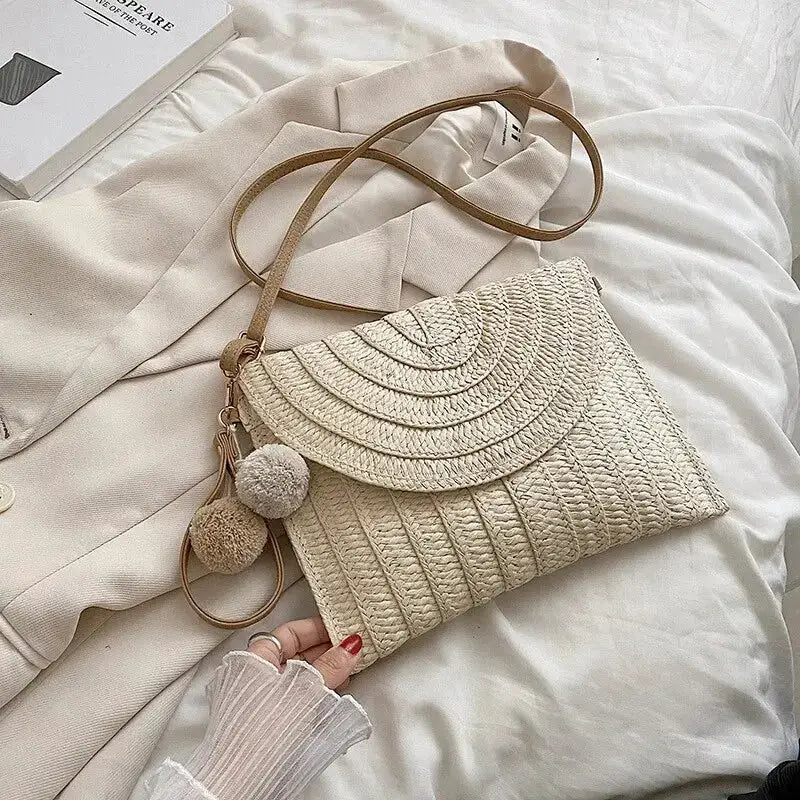 Handmade straw beach crossbody bag, cream woven envelope with tan strap and pom-pom tassels