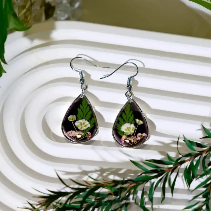 Simples Market teardrop resin earrings with pressed flowers and green leaves; silver hooks