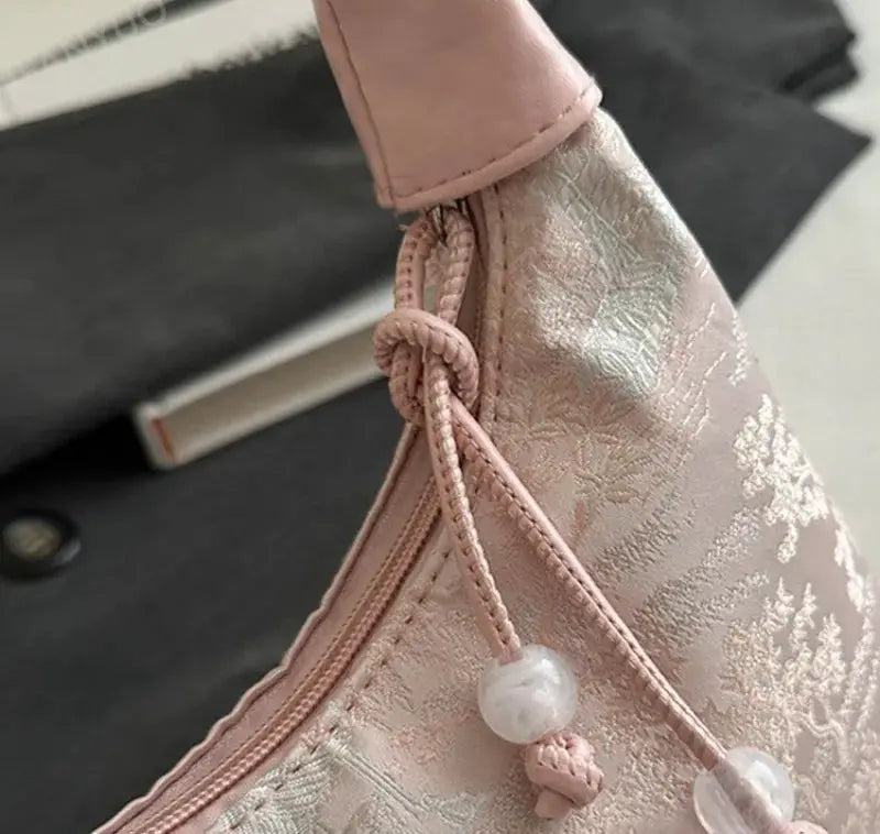 Pink Chinese-style embroidered handbag with drawstring tassels and pearl bead accents