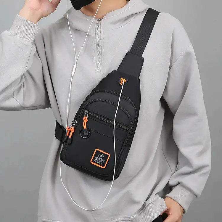 Men's black crossbody sling bag by Simples Market with orange zipper pulls; waterproof, compact hiking bag.