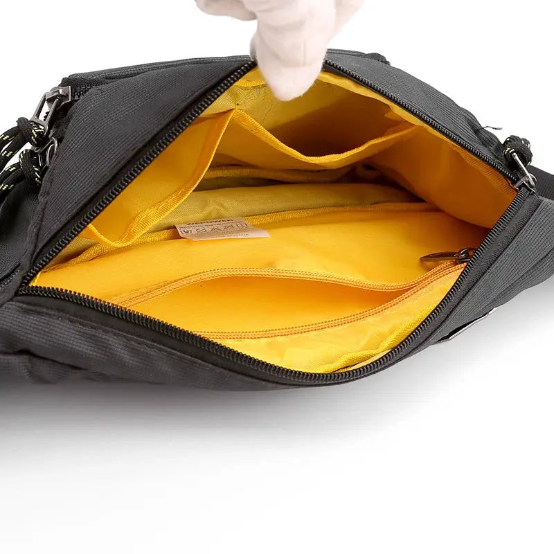 Men's waist fanny pack, black nylon with yellow interior and multiple pockets.