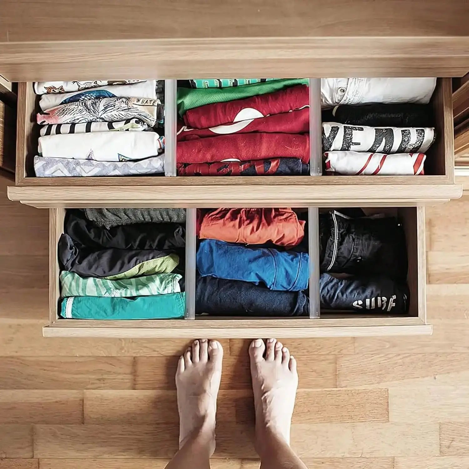 Expandable clear drawer dividers with 6 compartments, arranged in a wooden dresser to organize folded clothes