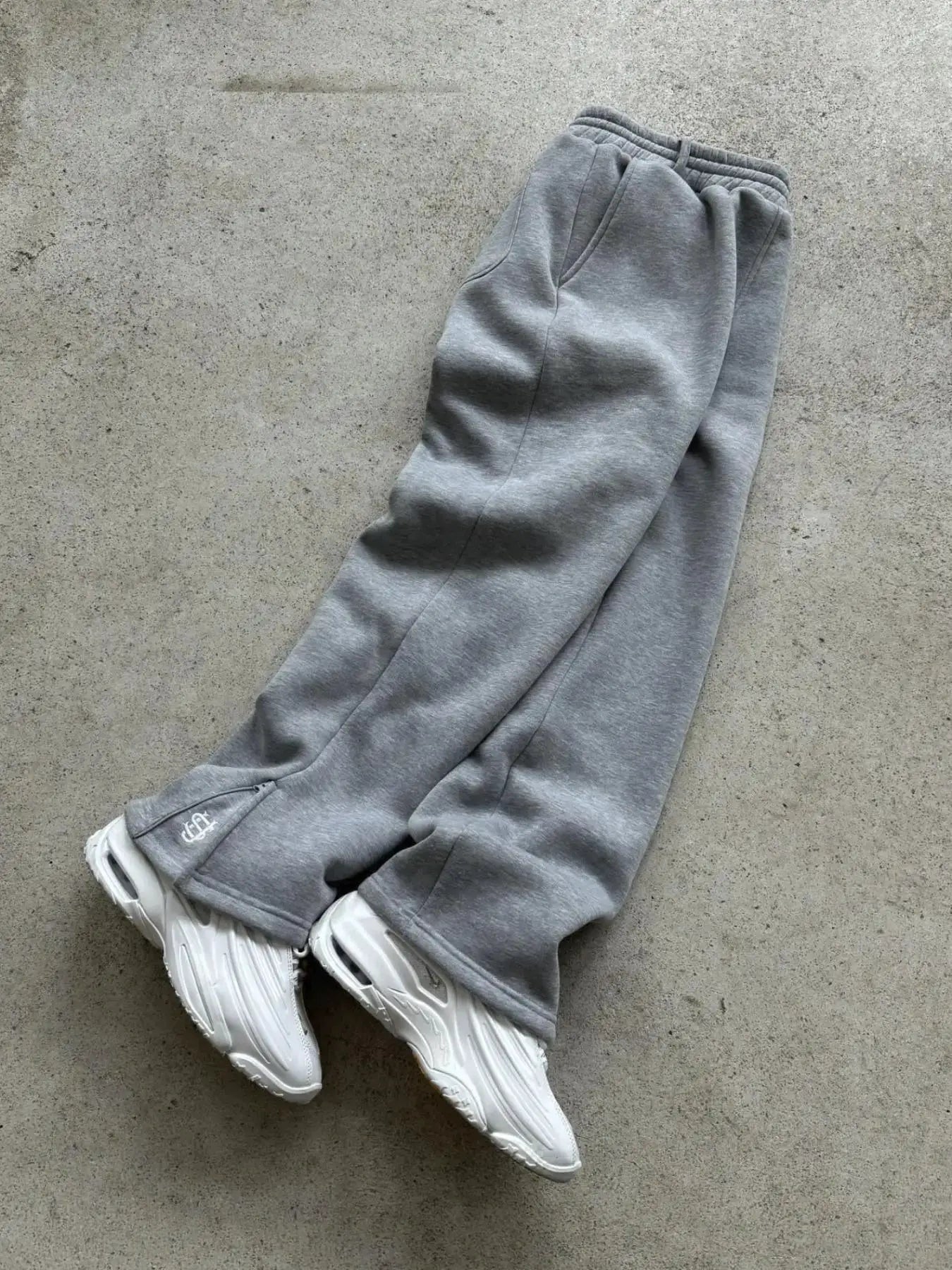 Men's grey jogger pants with elastic waistband; small brand logo at the ankle.