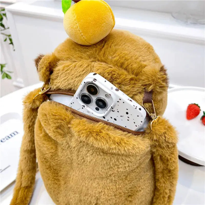 Capybara plush backpack by Simples Market, brown fuzzy crossbody bag with zipper; phone tucked in back pocket