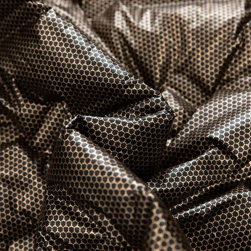 Men's down jacket fabric close-up; black with beige honeycomb pattern