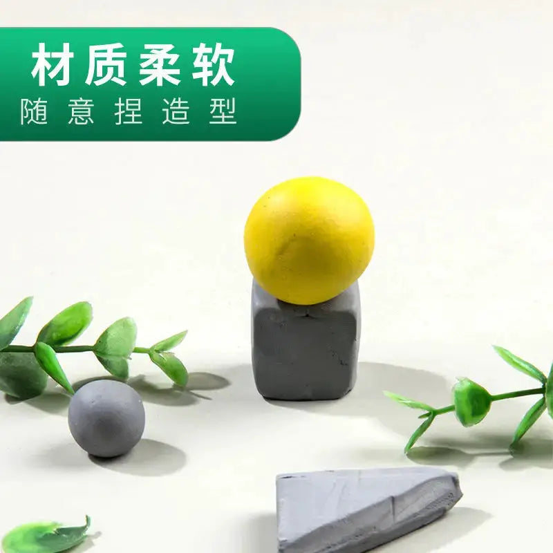 Faber-Castell Plasticity kneaded eraser display with a yellow ball on a gray cube and gray spheres