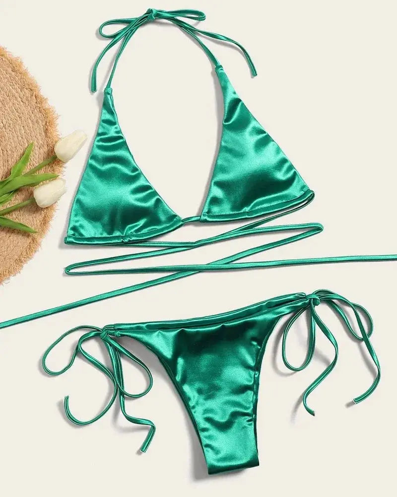 Bikini set by Simples Market, emerald green metallic satin halter two-piece with high-cut bottoms.