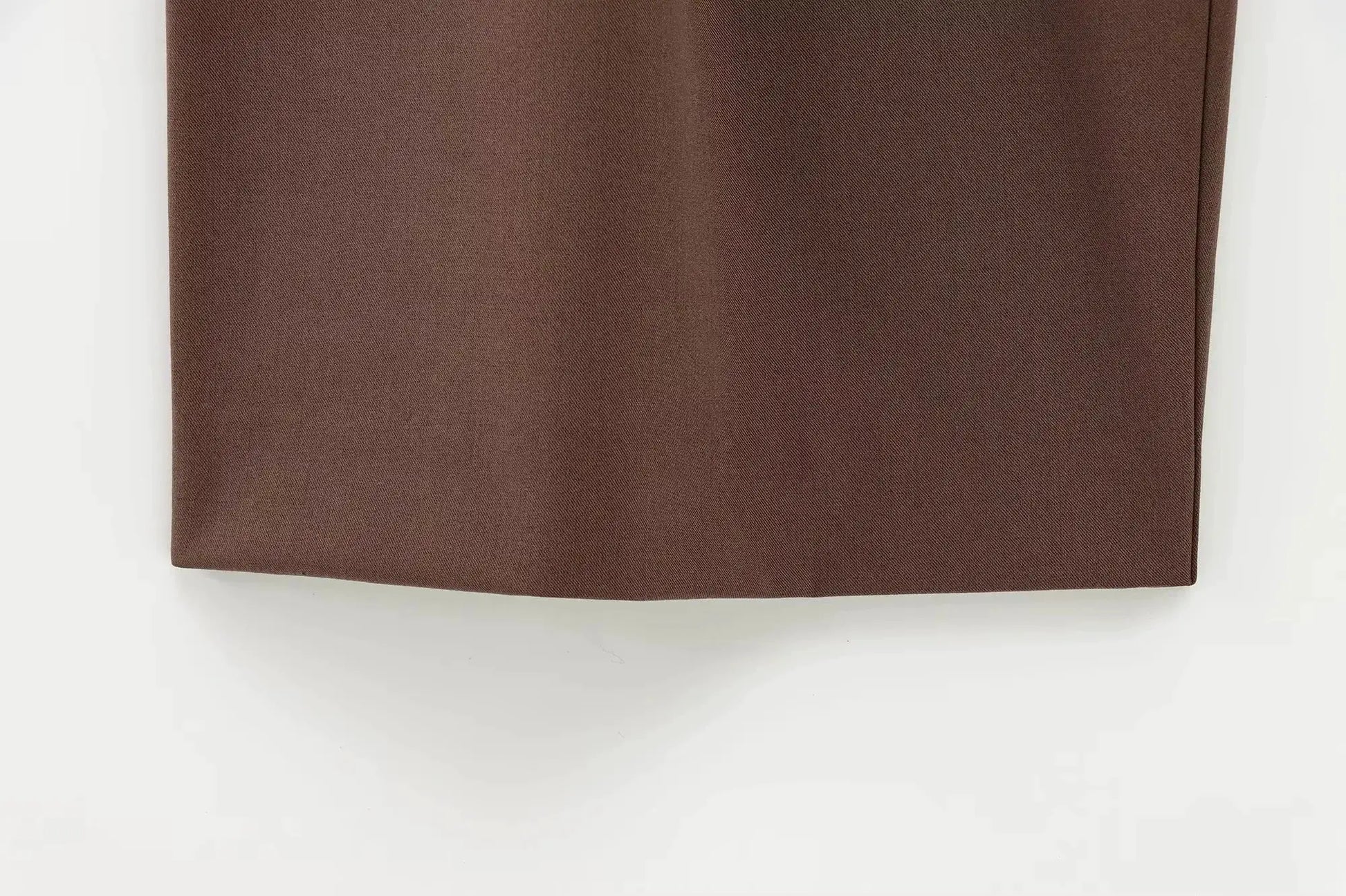 KONDALA brown suit fabric close-up; textured material with center seam and hem edge