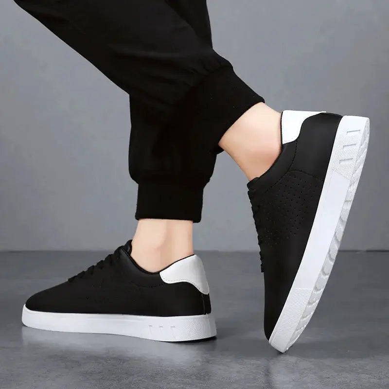 Pair of men's black casual leather lace-up sneakers with white soles and breathable perforated side panels.