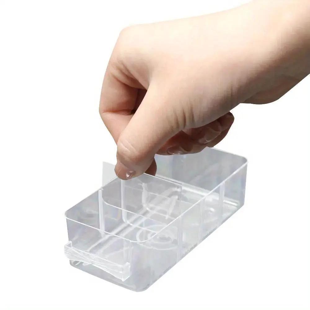 Clear plastic 25-grid drawer parts box with multiple compartments; hand holding it.