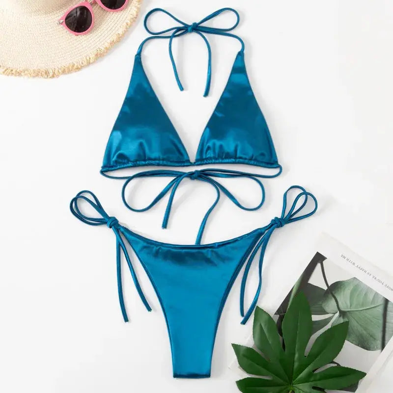 Two-piece bikini set: teal metallic satin with halter top and high-cut bottoms with tie sides.