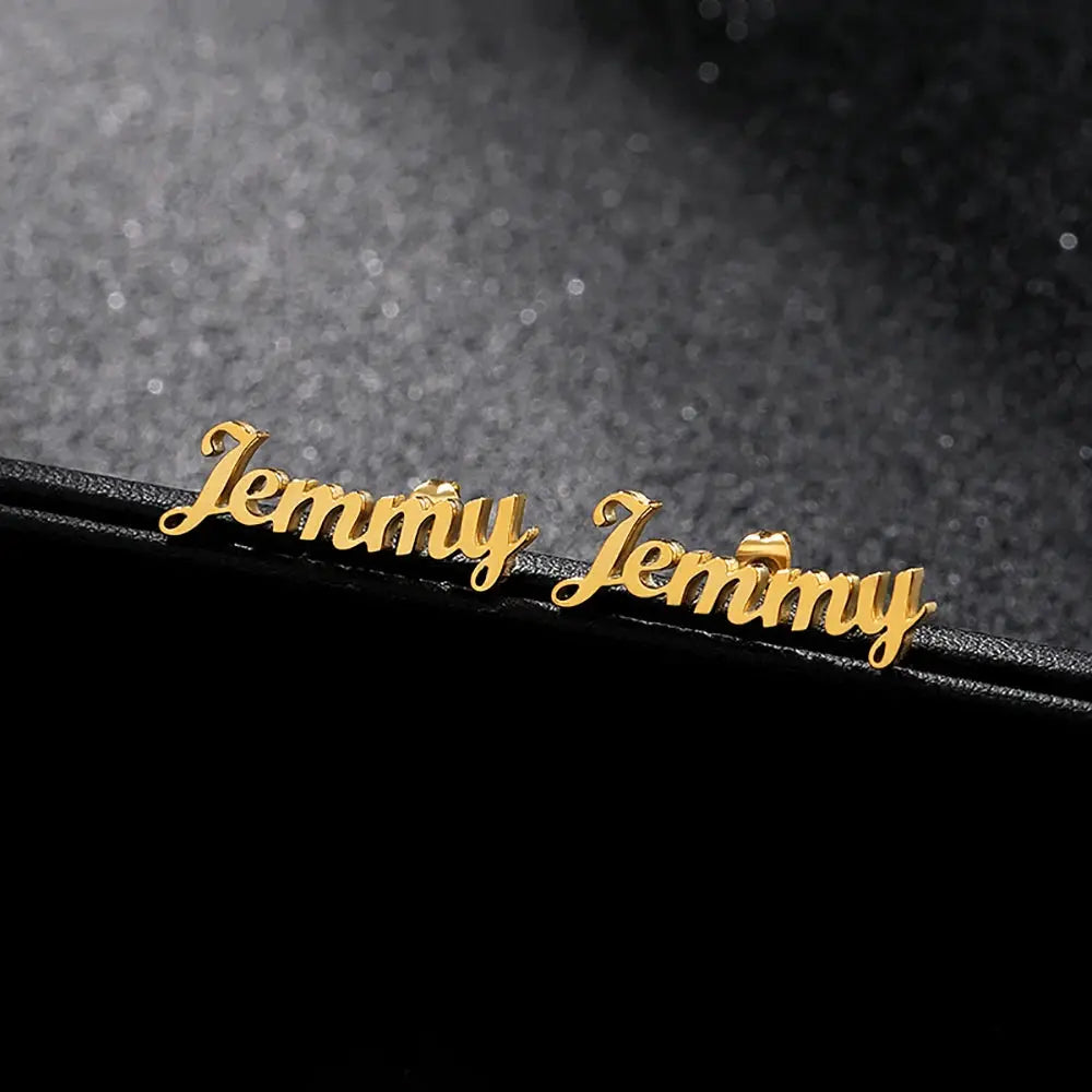 Pair of gold-tone stainless steel custom name stud earrings reading Jenny by Simples Market