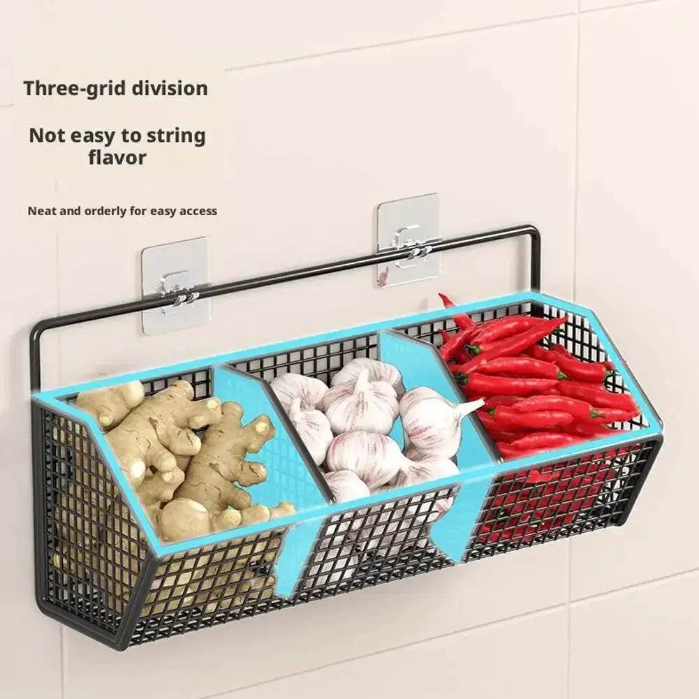 Wall-mounted three-compartment metal wire basket with blue dividers for spices, garlic, onions, and peppers.