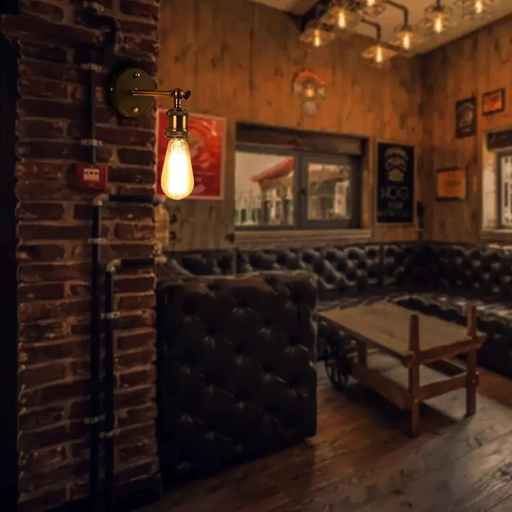 American single-head brass wall lamp with Edison bulb, industrial style, wall-mounted in a cozy lounge.