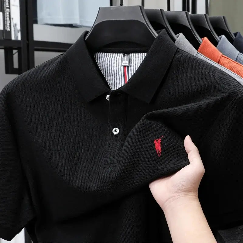 Polo shirt, black cotton with red embroidered pony logo; five polo shirts on display in assorted colors.