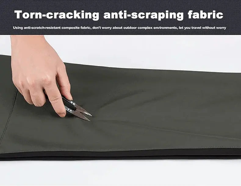 JNLN hiking pants fabric swatch in olive green being torn with scissors, showing anti-scraping fabric