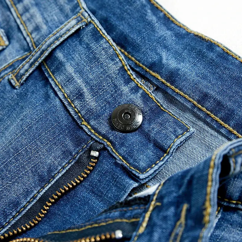 Men's blue denim shorts with zip fly and metal button, gold contrast stitching.
