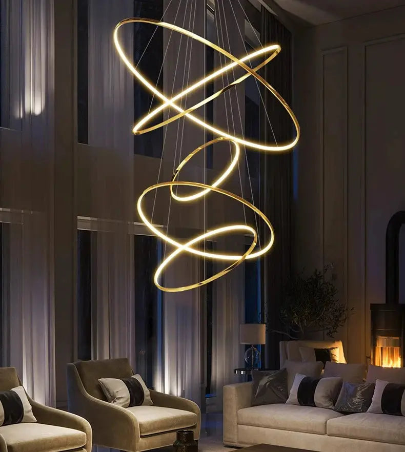 Modern LED pendant light with gold circular rings hanging chandelier over living room seating.