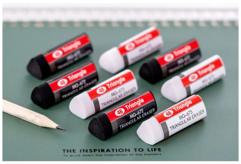 4B triangle erasers set with red and white labels on a green desk, pencil nearby.