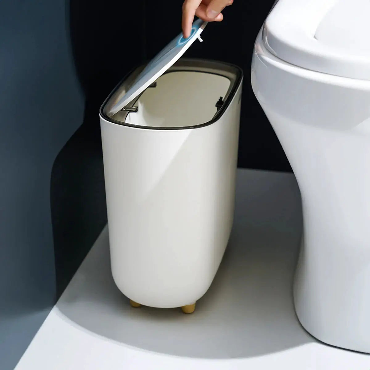 Narrow white bathroom trash can with lid by Simples Market, slim design fits bathroom gap.