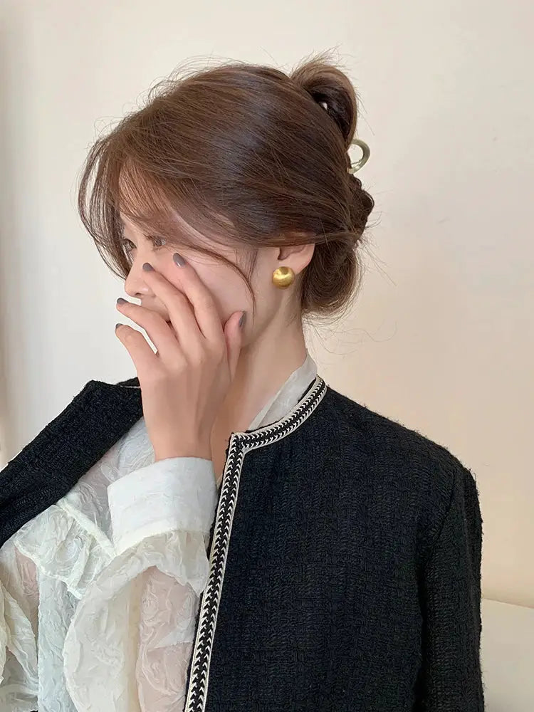 Earrings: a pair of gold metal stud earrings with large rounded spheres