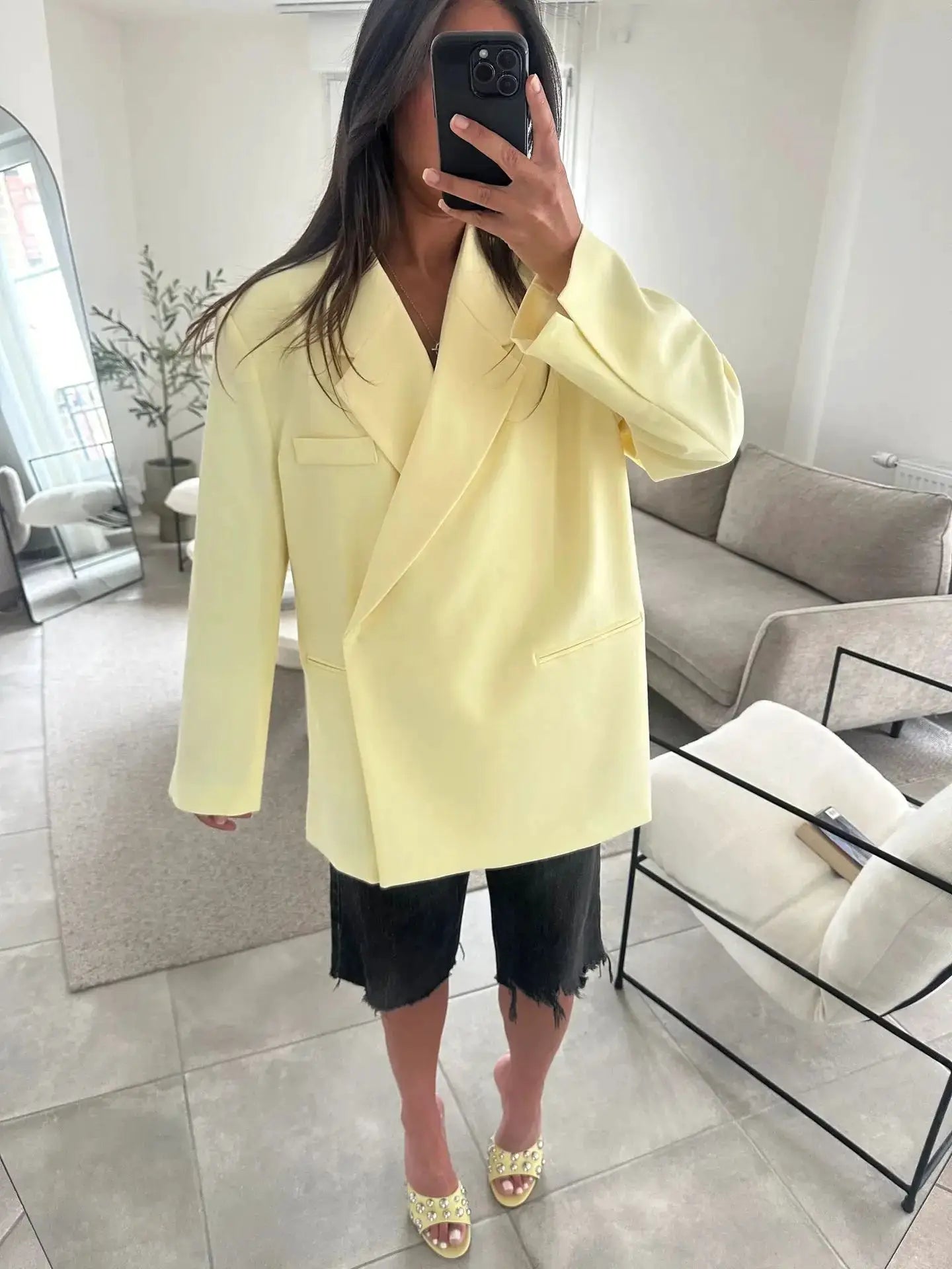 Ladies loose yellow blazer with turn-down collar and single button, paired with black distressed shorts