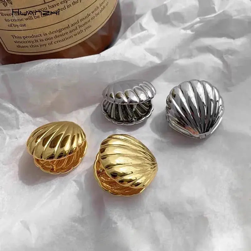 Shell texture ocean-style stud earrings set of four in gold and silver tones.
