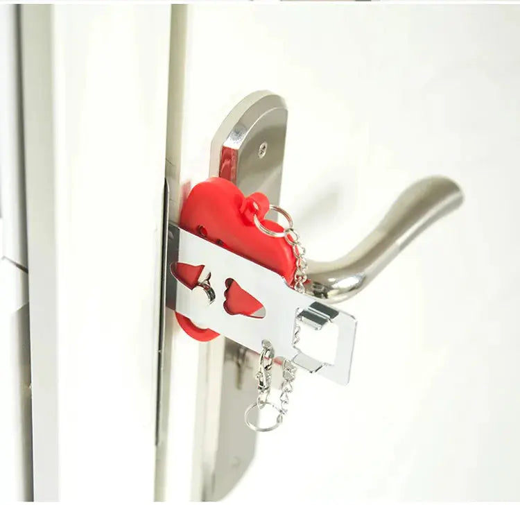 Portable door lock latch by Simples Market with red heart-shaped padlock securing a metal strike plate on a silver door handle