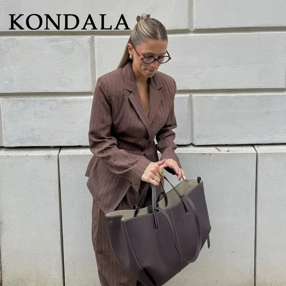 KONDALA brown striped office suit blazer with matching wide-leg pants, model carrying a taupe tote bag