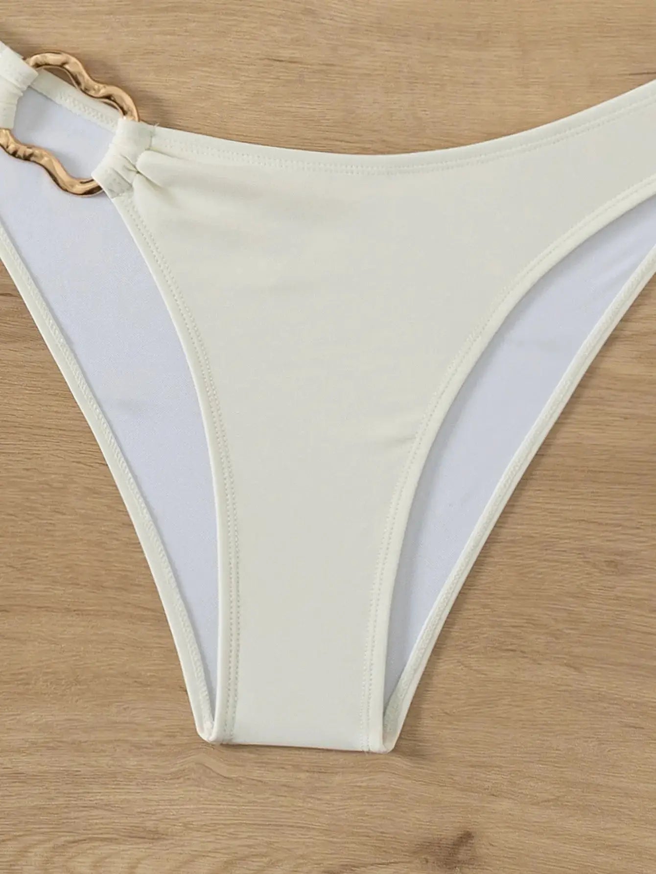 Bikini bottom by Simples Market, ivory with light blue side panels and gold ring detail.