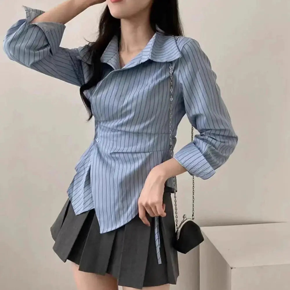 Women’s light blue striped long-sleeve blouse with collar, slim fit, shown with a dark pleated skirt