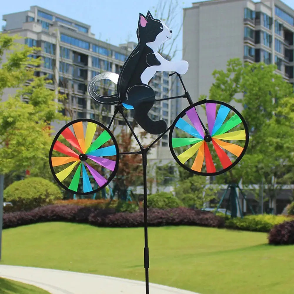 Animal riding wind spinner on a tall stake with rainbow-spoked bicycle wheels for garden decoration