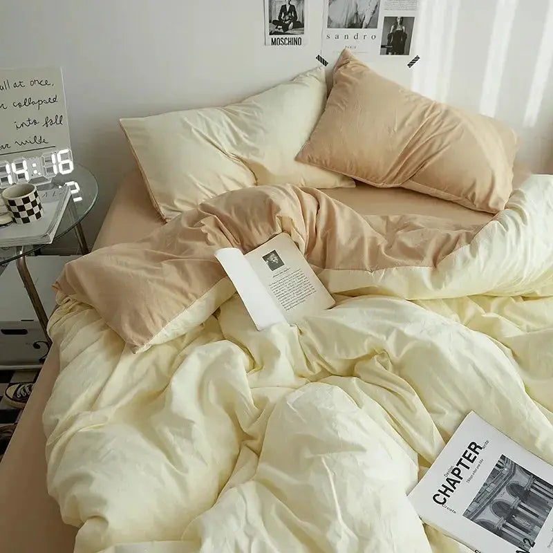 4-piece solid-color double-washed cotton bedding set in cream and beige on a bed with pillows.