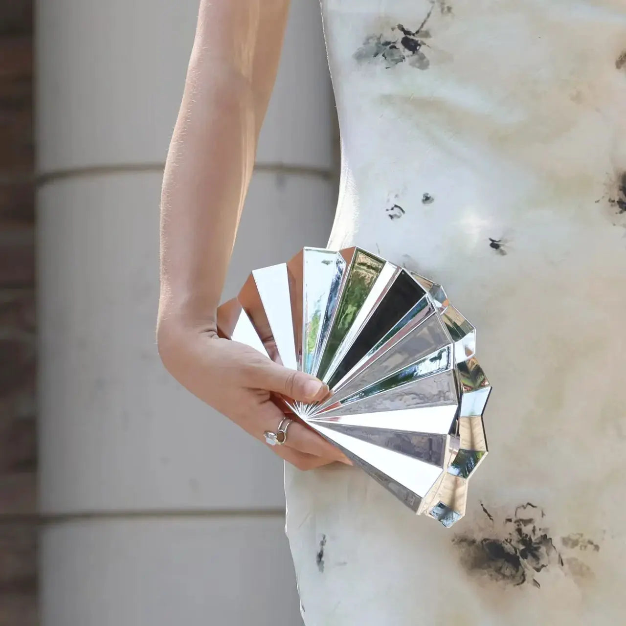 Moon-shaped silver acrylic purse; hand-held evening bag with mirrored, fan-like panels