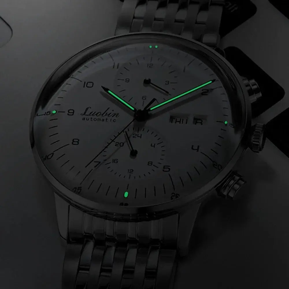 Men's automatic wristwatch with stainless steel band and luminous green hands.