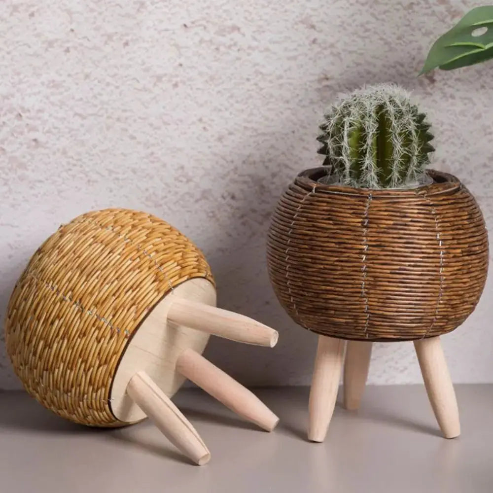 Two rattan woven flower pots with removable legs; brown cactus pot and light straw planter on wooden tripod legs