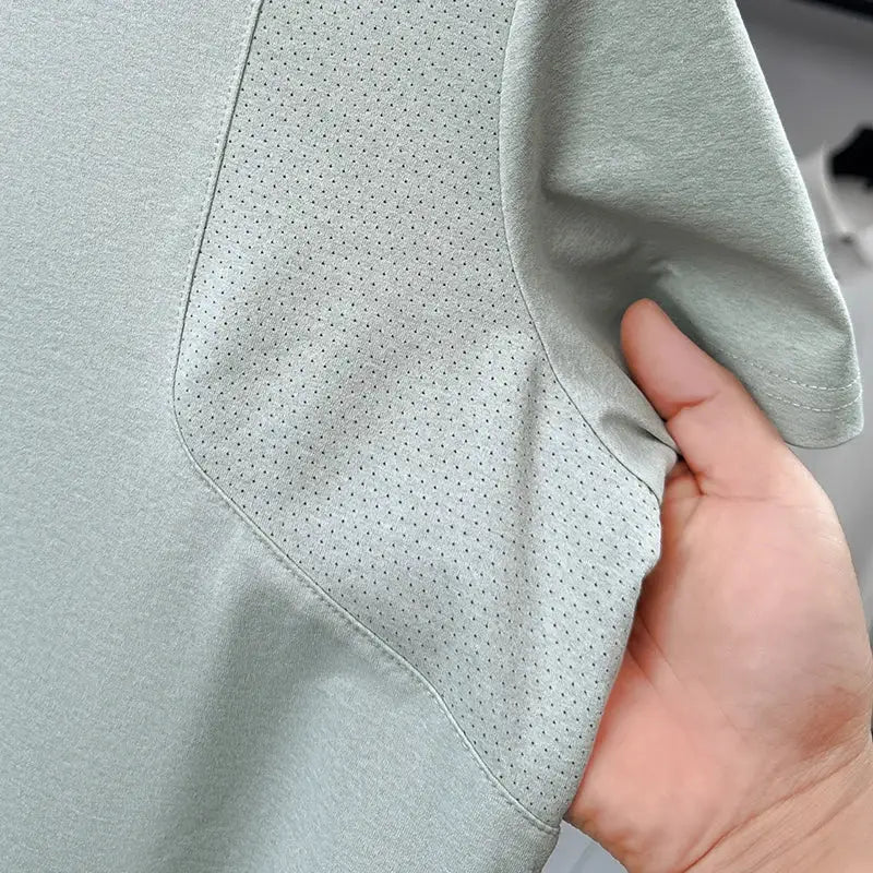 Men's polo shirt with short sleeves in light sage-green; perforated vent panel for breathable comfort