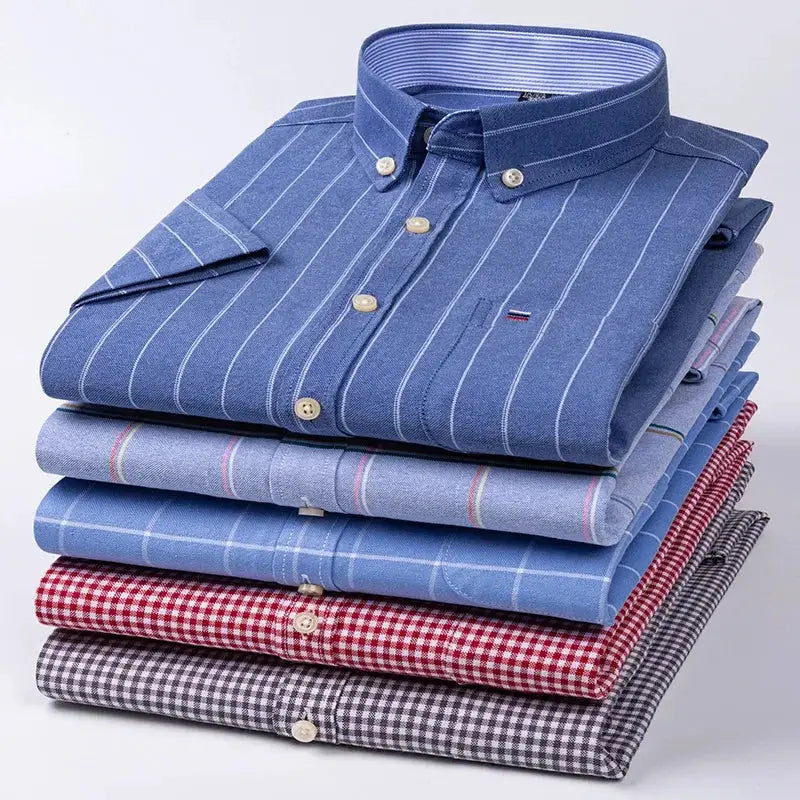 Men's cotton oxford social shirts stacked; 6 assorted blue striped and plaid button-downs.