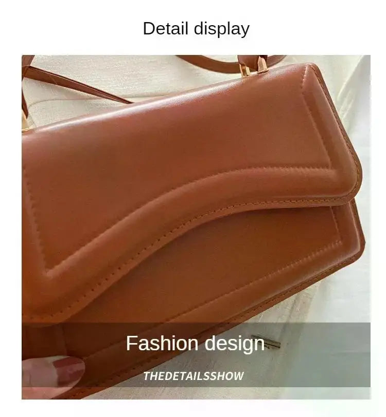 PU leather handbag in tan with curved flap and crossbody shoulder strap