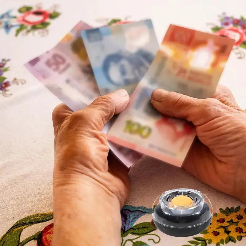 Round finger-wetting money counting tool; black base, clear lid, yellow center beside banknotes, Simples Market
