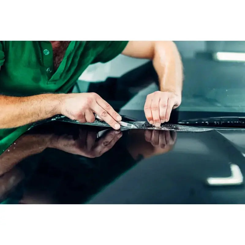 Car gloss PPF clear protection vinyl film being applied to a car hood