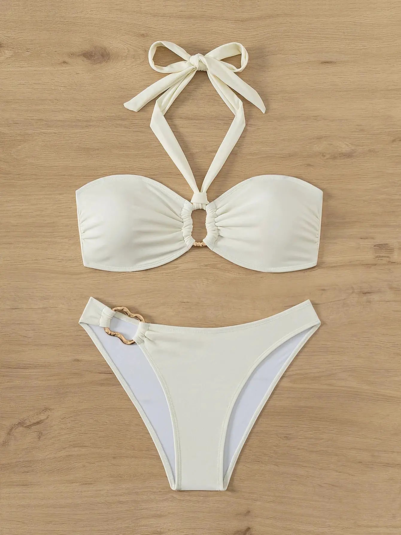 White bandeau push-up bikini set with halter ties and ruched center; thong bottoms with gold ring detail