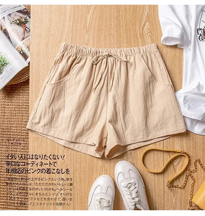 Women’s beige linen shorts with drawstring waist and front pockets, shown with white sneakers.