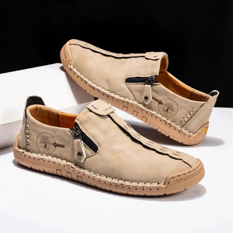 Handmade beige leather men's slip-on loafers with side zippers and moccasin-style stitching.