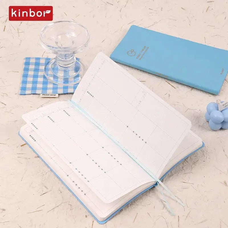 Kinbor weekly planner notebook with blue cover, undated diary and grid-page layouts.
