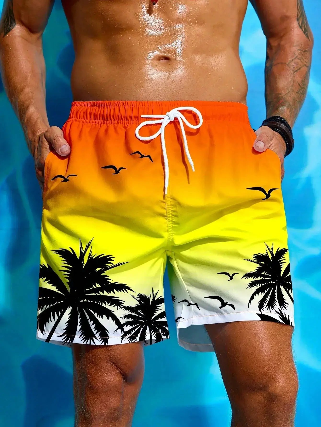Men's gradient orange-to-yellow board shorts with palm silhouettes and white drawstring