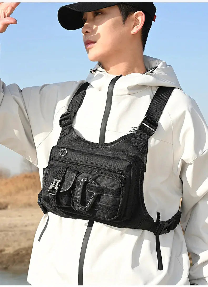 Outdoor Tactical Chest Bag for Men in black with multiple front pockets and carabiner, worn over a white jacket