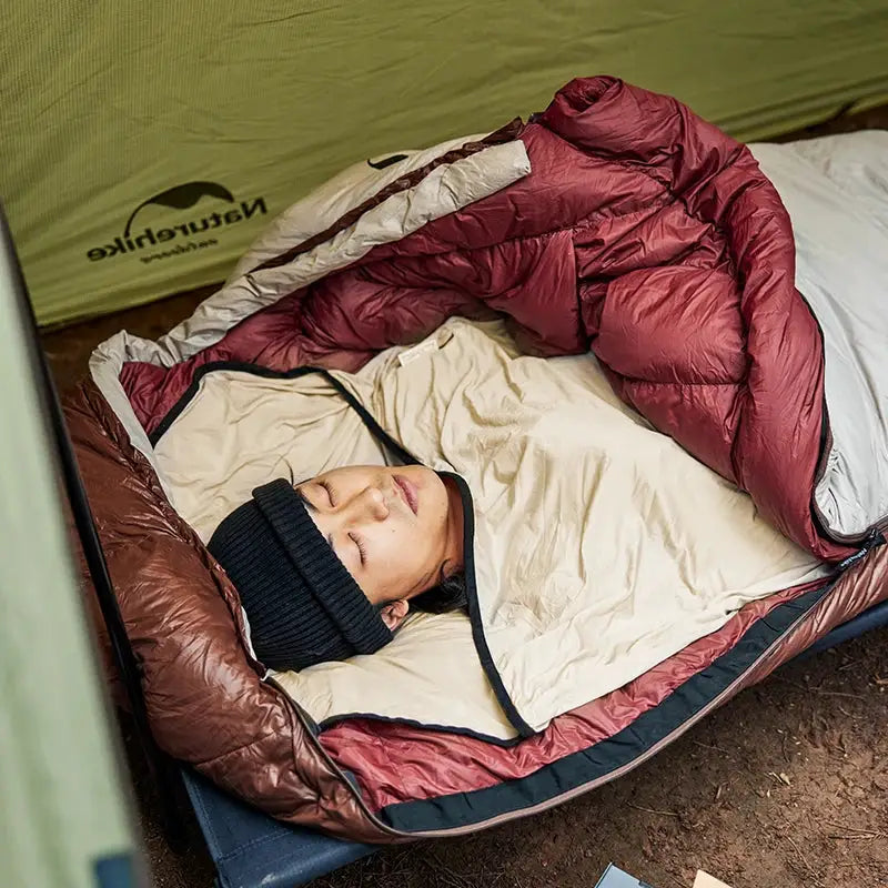 Sleeping bag liner, Naturehike beige with dark trim inside a maroon mummy sleeping bag