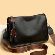 Leather tote bag for women with black genuine leather and brown adjustable strap tassel accents.